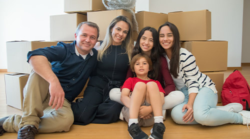 Family sitting on the floor behind the boxes photo